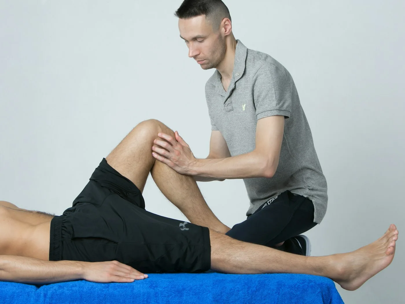 Physiotherapeut unterstützt einen Patienten bei einer gezielten Dehnübung des Knies